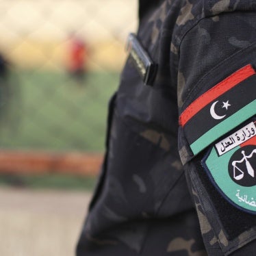 An emblem on the uniform of a judicial police guard standing at a prison