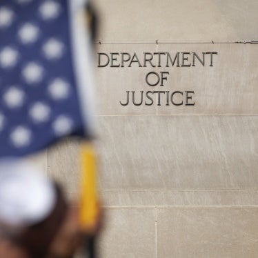 People pass the Department of Justice during a march against Trump administration policies in Washington, DC, March 4, 2025. 
