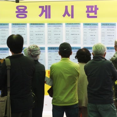 Older people look at a recruitment bulletin board at a job fair