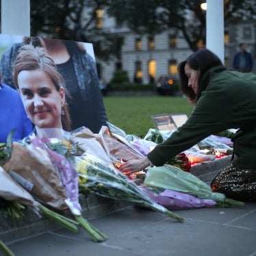 Floral tributes and candles are placed by a picture of slain Labour MP Jo Cox at a vigil in Parliament square in London on June 16, 2016.