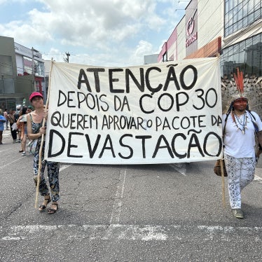 Activists carry a banner warning of efforts to dismantle environmental licensing requirements in Brazil.