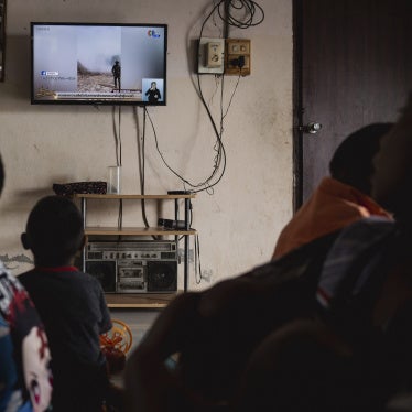 Children watch news reports about the situation along the Thai-Cambodian border, in Sisaket province in northeastern Thailand, July 27, 2025.