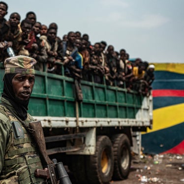 An M23 fighter in front of a truck with detained Congolese soldiers.