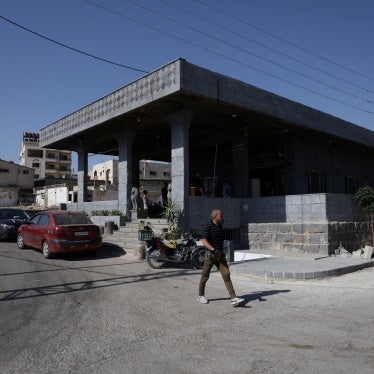 A person walks past the Al-Radwan guest house, where a deadly shooting occurred, in the predominantly Druze city of Sweida, Syria, July 25, 2025. 