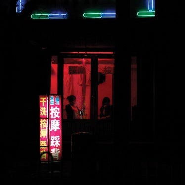 Two women sit near the window of a massage salon on a street in the city of Weifang in Shandong Province on April 20, 2011.