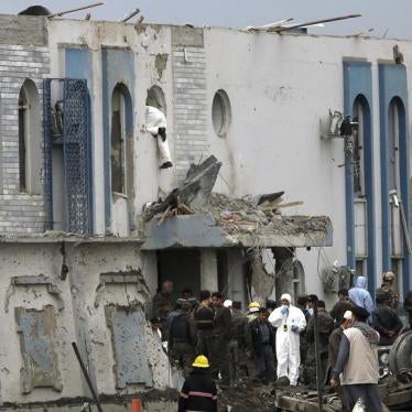 A forensic expert inspects through a window of a government security building after a blast in Kabul, Afganistan, April 19, 2016.