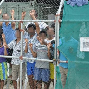 Asylum-seekers look through a fence at the Manus Island detention centre in Papua New Guinea March 21, 2014. 