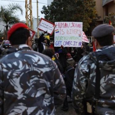 Lebanese police stand guard as protesters carry banners during a sit-in for LGBT rights in Beirut. 