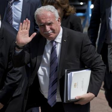 Palestinian Foreign Minister Riyad al-Maliki waves as he arrives holding documents he will submit to the International Criminal Court in The Hague, Netherlands, Thursday, June 25, 2015.