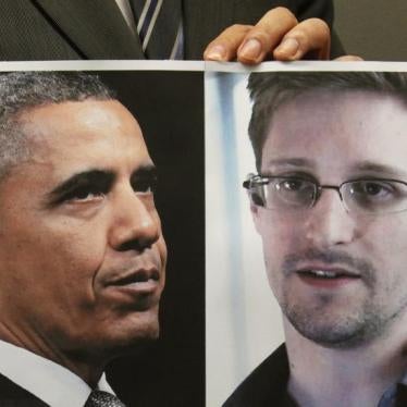 A supporter of Edward Snowden holds a combination photo featuring U.S. President Barack Obama and Edward Snowden, during a news conference in Hong Kong on June 14, 2013.
