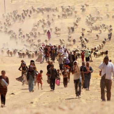 Displaced people from the minority Yezidi sect, fleeing violence from forces loyal to the Islamic State in Sinjar town, walk towards the Syrian border, on the outskirts of Sinjar mountain, near the Syrian border town of Elierbeh of Al-Hasakah Governorate 