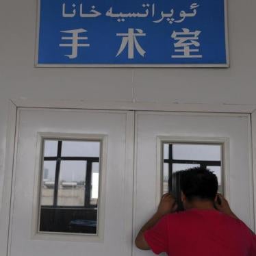 A man looks through a window on the door of an operating room as his wife undergoes a caesarean section at a hospital in Shaya county, Xinjiang Uighur Autonomous Region June 4, 2012.