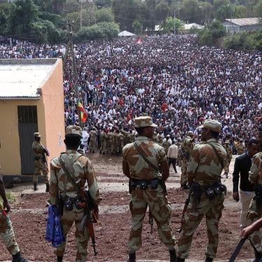 Armed security officials watch as protesters stage a protest against government during the Irreechaa cultural festival in Bishoftu, Ethiopia on October 02, 2016.