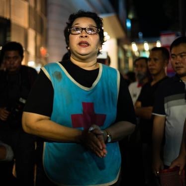 On August 30, 2017, Phayao Akhard wears the bloody nurses gown worn by her daughter, nurse Kamolkate “Kate” Akhard, when she was killed by Thai Special Forces soldiers while tending wounded persons at the front of Wat Pathum temple on May 19, 2010, to pro