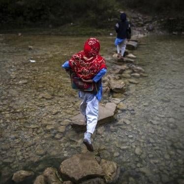 A girl crosses a stream as she walks to school in Margalla Hills, Islamabad, October 24, 2014.