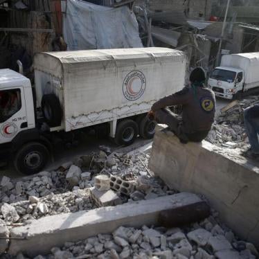 Civil defence members sit amid the rubble as they watch an aid convoy of Syrian Arab Red Crescent driving through the besieged town of Douma, Eastern Ghouta, Damascus, Syria March 5, 2018. 