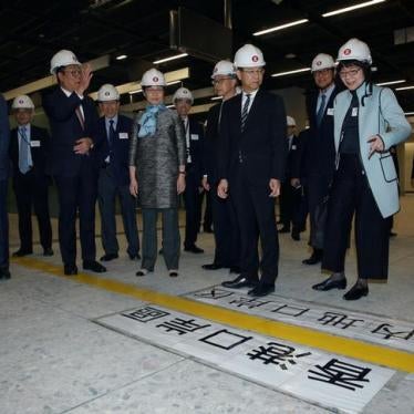 Hong Kong Chief Executive Carrie Lam and other officials stand in front of a line dividing Hong Kong and mainland Chinese control zone as part of the joint immigration checkpoint inside West Kowloon Terminus
