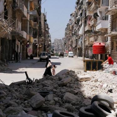 A woman walks with a child amid rubble at Bustan al-Qasr neighbourhood in Aleppo, Syria July 16, 2017.