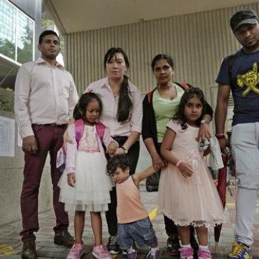Asylum seekers, from left: Ajith Pushpa Kumara, Vanessa Mae Rodel and her daughter Keana, Nadeeka Dilrukshi Nonis and her son Dinath and daughter Sethmundi Kellapatha, and Supun Thilina Kellapatha, pose outside the building of Hong Kong's immigration depa