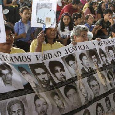 Women carry a banner of photos of missing persons on a day dedicated to the children who went missing during El Salvador's armed conflict in San Salvador, El Salvador, Tuesday March 29 , 2011.