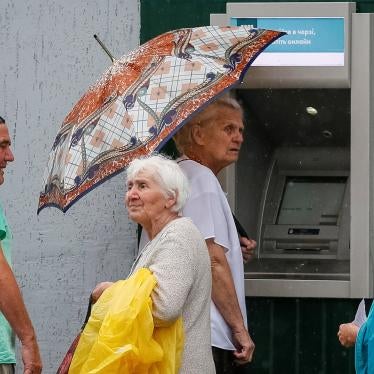 People stand near an ATM, located near the contact line between Russia-backed armed groups and Ukrainian troops in Mayorsk, Ukraine. 