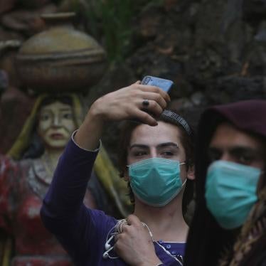 Transgender people wearing face masks as a precaution against COVID-19 take selfies at a park in Peshawar, Pakistan, March 20, 2020.