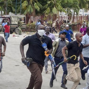 Ferry passengers flee from police firing tear gas, after new measures aimed at halting the spread of the new coronavirus instead caused a crowd to form outside the ferry in Mombasa, Kenya Friday, March 27, 2020. 