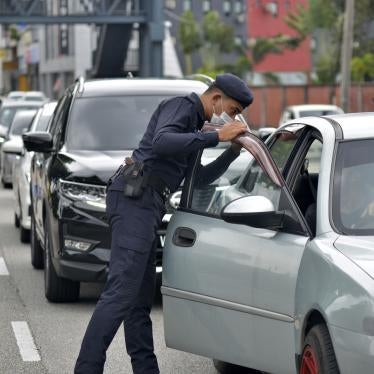 Police officers check vehicles at a roadblock to ensure that people abide by the movement control order in downtown Kuala Lumpur, Malaysia, March 19, 2020. © 2020 AP Photo
