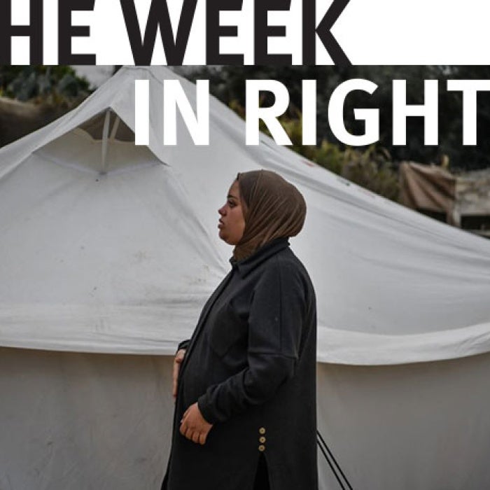 One woman stands in front of tent.